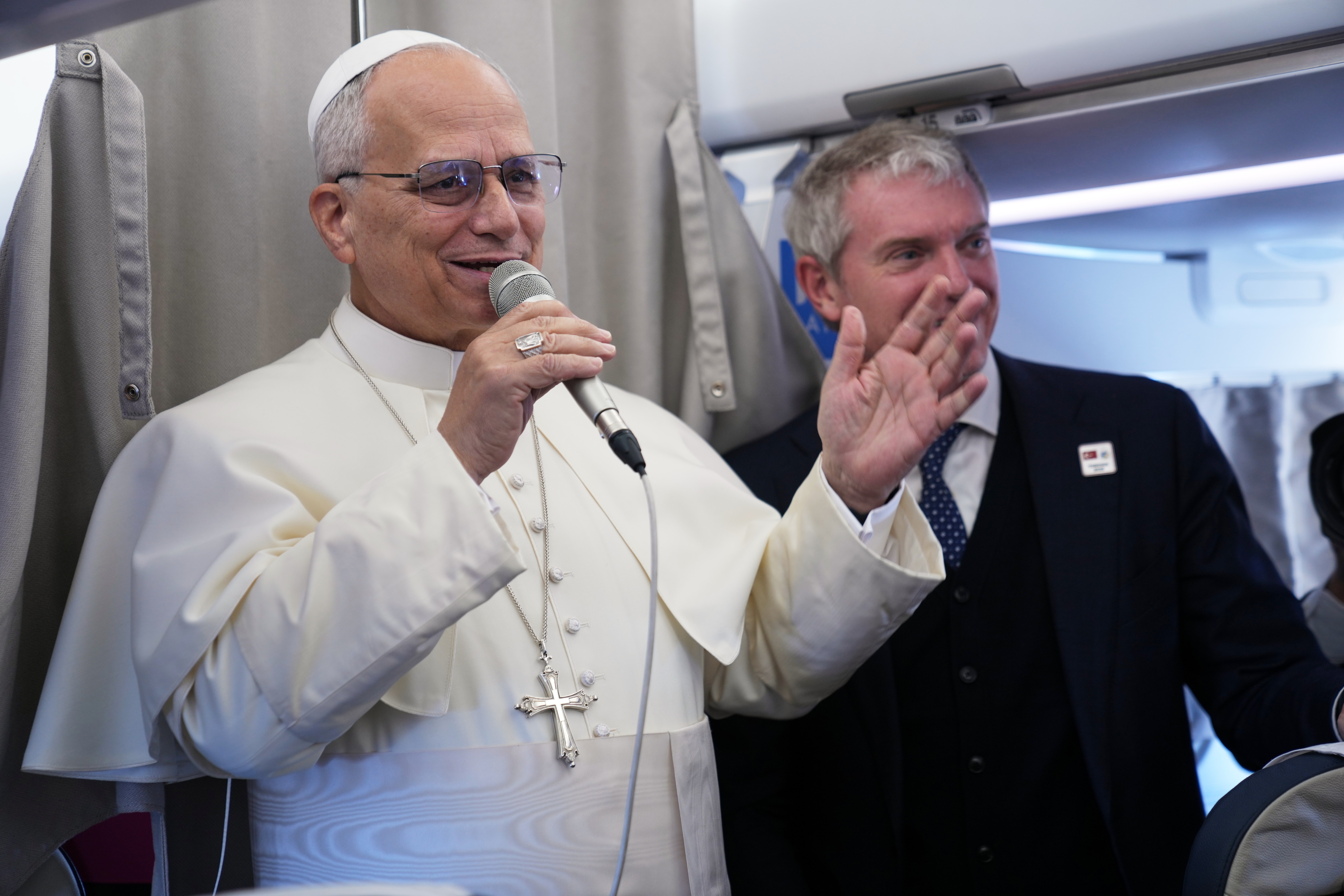 Pope Leo XIV greets reporters aboard a flight on his way to Ankara, Turkey, for a six-day trip to Turkey and Lebanon, Thursday, Nov. 27, 2025.